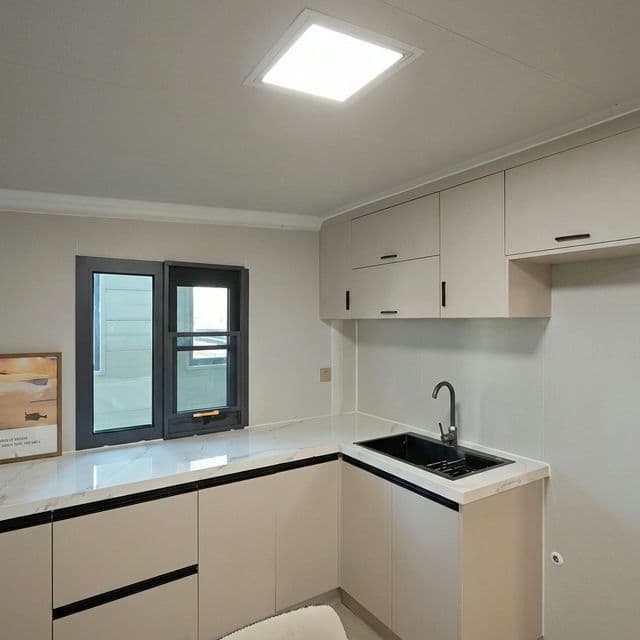 Granny flat kitchen with white cabinetry, benchtop, and integrated sink